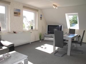 a living room with a television and a table at Ferienwohnung ERNA HORS110 in Wangerland