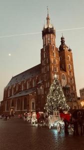 a christmas tree in front of a large building at Glamorous Apartment Old Town Cracow in Kraków
