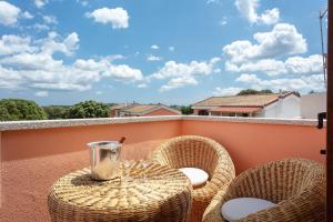 patio con sillas de mimbre y mesa en el balcón en Tortuga House - private Jacuzzi -, en Telti