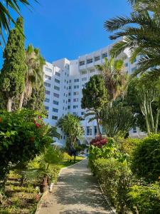 un gran edificio blanco con palmeras y una pasarela en Kenzi Solazur, en Tánger