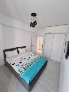 1 dormitorio con 1 cama en una habitación blanca en Daric Residence Apartaments, en Fălticeni
