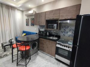 a small kitchen with a stove and a microwave at Luxury Host -219- Dream Land in 6th Of October