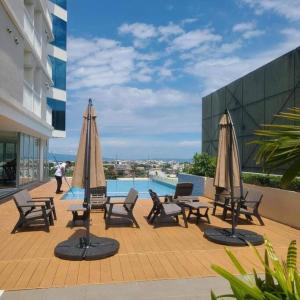 ダバオシティにあるTinch at Inspiria Condominium Davao City Unit 1527のプールサイドの椅子とパラソルのグループ
