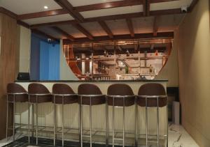 um bar com um monte de bancos num quarto em Hotel JK Celebration em Jabalpur