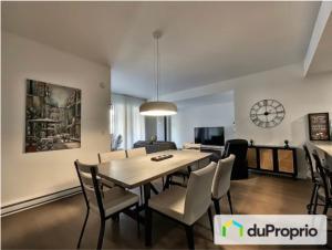 a dining room and living room with a table and chairs at Condo in Quebec City