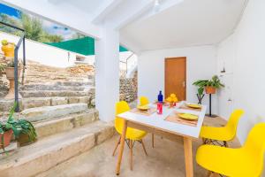 ein Esszimmer mit einem Tisch und gelben Stühlen in der Unterkunft Can Bessó Mancor de la Vall in Mancor del Valle