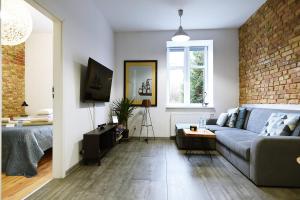 a living room with a couch and a brick wall at Mini Loft Janickiego in Szczecin