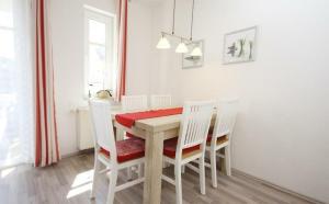 キュールングスボルンにあるStrandschloesschen-Haus-II-WE-18-9723のダイニングルーム(木製テーブル、白い椅子付)