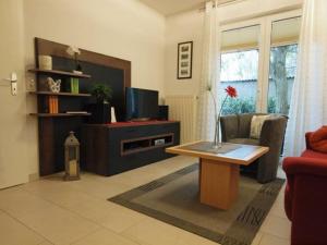 a living room with a tv and a table at Strandschloesschen-Haus-II-WE-4-9699 in Kühlungsborn