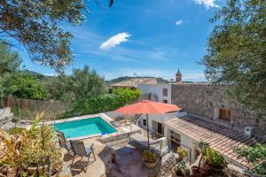Villa mit einem Pool und einem orangenen Sonnenschirm in der Unterkunft Can Bessó Mancor de la Vall in Mancor del Valle
