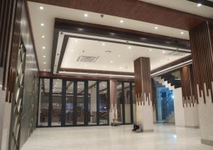 ein großes Gebäude mit einer Lobby mit Glastüren in der Unterkunft Hotel JK Celebration in Jabalpur