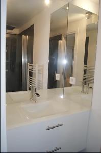La salle de bains est pourvue d'un lavabo et d'un miroir. dans l'établissement Le Gîte de l'Océan, à Lège-Cap-Ferret