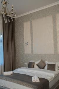 a bedroom with a large bed with two towels on it at BMG Hotel by Grigoryans Group in Goris