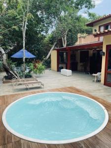 ein großer Pool mit Wasser auf einer Holzterrasse in der Unterkunft Casa ampla em condomínio fechado com área de lazer completa in Búzios