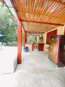 eine große Terrasse mit Holzdecke und eine Küche in der Unterkunft Casa ampla em condomínio fechado com área de lazer completa in Búzios