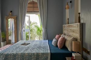 a bedroom with a bed with a wooden head board at LohonoStays Villa Aurelia E in Vagator