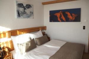 ハイリゲンブルートにあるFerienwohnung Gompitzerのベッドルーム1室(白いシーツと枕のベッド1台付)