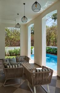 瓦加托的住宿－LohonoStays Villa Aurelia E，带沙发和椅子的客厅以及游泳池。