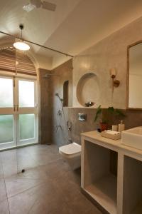 a bathroom with a toilet and a sink and a shower at LohonoStays Villa Aurelia E in Vagator