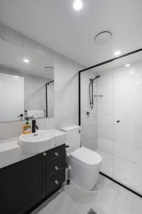 e bagno con servizi igienici, lavandino e doccia. di Hidden 2BR1BA Apt w parking walk to Westfield a Brisbane