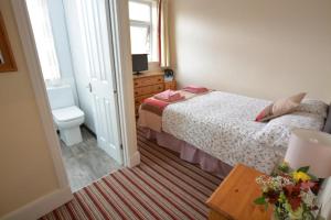 a small bedroom with a bed and a toilet at ALARA Bed and Breakfast in Sheffield