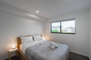 una camera da letto con un grande letto e una finestra di Hidden 2BR1BA Apt w parking walk to Westfield a Brisbane