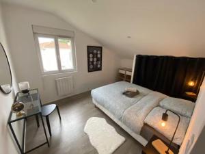 a bedroom with a large bed and a window at Maison T4 proche Bordeaux in Lormont