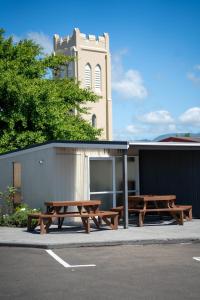 Viking Lodge Motel في Tahoraiti: طاولتان للتنزه على جانب موقف السيارات