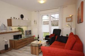 a living room with a red couch and chairs at Strandschloesschen-Haus-II-WE-3-9734 in Kühlungsborn