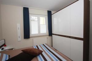 een slaapkamer met een bed en een raam bij Strandschloesschen-Haus-II-WE-3-9734 in Kühlungsborn