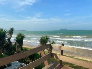 une vue sur l'océan depuis une clôture en bois dans l'établissement Casa Búzios pé na areia, à Búzios 5 autres photos