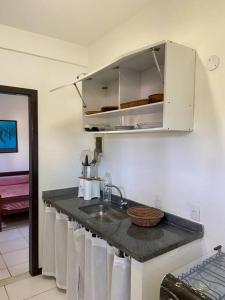 - une cuisine avec un évier et un comptoir avec des serviettes dans l'établissement Casa Búzios pé na areia, à Búzios
