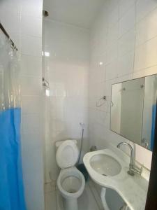 une salle de bains blanche avec toilettes et lavabo dans l'établissement Casa Búzios pé na areia, à Búzios