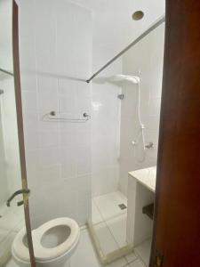 une salle de bain blanche avec toilettes et douche dans l'établissement Casa Búzios pé na areia, à Búzios