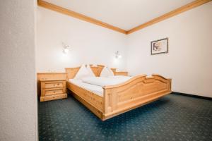 um quarto com uma grande cama de madeira num quarto em Appartementhaus Lackner em Grossarl
