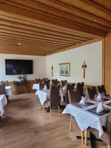 a dining room with tables and chairs and a flat screen tv at Dinh Residence in Zweisimmen