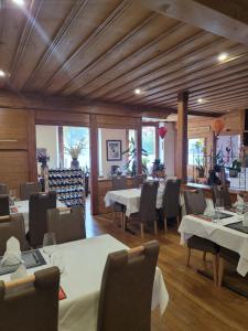 une salle à manger avec des tables et des chaises blanches dans l'établissement Dinh Residence, à Zweisimmen