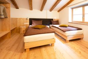 two beds in a room with wooden floors at Appartstube Wasserfallspitz in Sand in Taufers