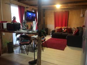 sala de estar con sofá, mesa y TV en Los carbon, en Ancud