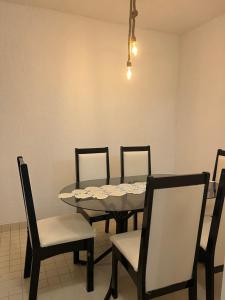 a dining room with a table and chairs and a light at Triplex Vista Azul in Rio das Ostras +8 photos