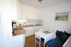 - une petite cuisine avec une table et un comptoir dans l'établissement Atlantik - Strandstr 15, App 12, à Wenningstedt