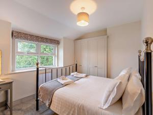 a bedroom with a bed with white sheets and a window at 2 Bed in Keswick 90064 in Threlkeld