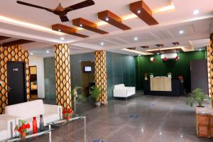 um átrio com uma ventoinha de tecto e paredes verdes em Green View Residency em Greater Noida