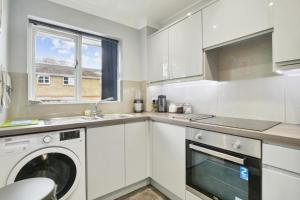 a white kitchen with a washing machine in it at Penthouse Long Stay Gem Free Parking Ideal in Brookwood