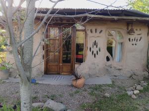 a small house with a wooden door in a yard at Casa Madre in Villa Yacanto