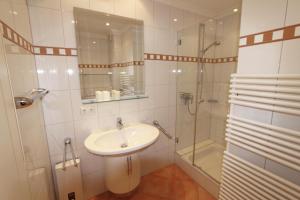 a white bathroom with a sink and a shower at Dünental 6b in Wenningstedt +29 photos