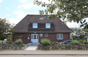uma casa de tijolos vermelhos com uma porta branca em Steffi - Ostmarkstr 20, App 2 em Wenningstedt