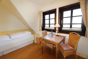 a small room with a table and a bed and window at Dünental 6b in Wenningstedt