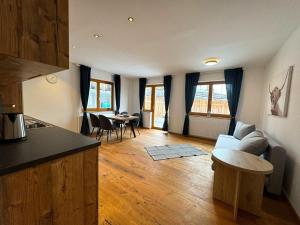 uma cozinha e sala de estar com um sofá e uma mesa em Amazing Apartment with private garden em Neustift im Stubaital