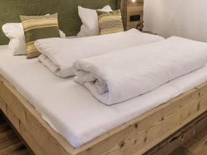 Duas camas com lençóis brancos e almofadas em Amazing Apartment with private garden em Neustift im Stubaital